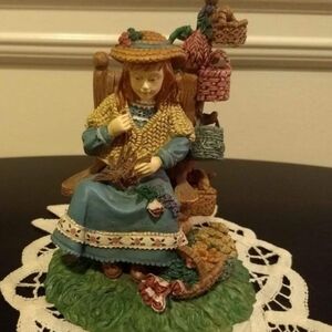 Beautiful girl in a rocking chair with her baskets and flowers.